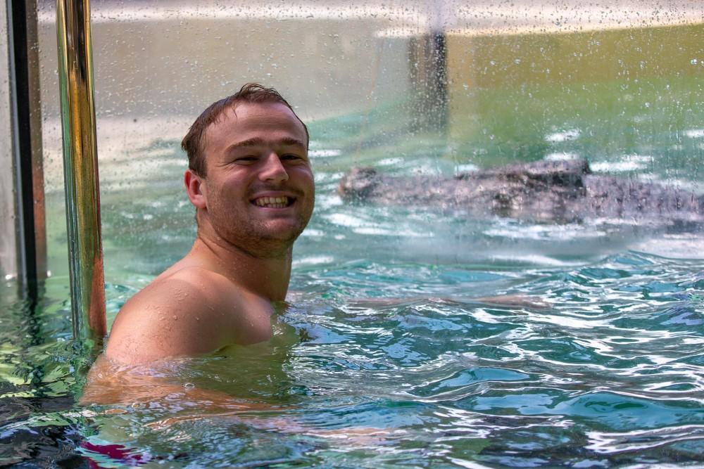 Harry Wilson swimming with a croc as part of the 'Reds to Region' Tour. Photo: QRU/Tom Mitchell